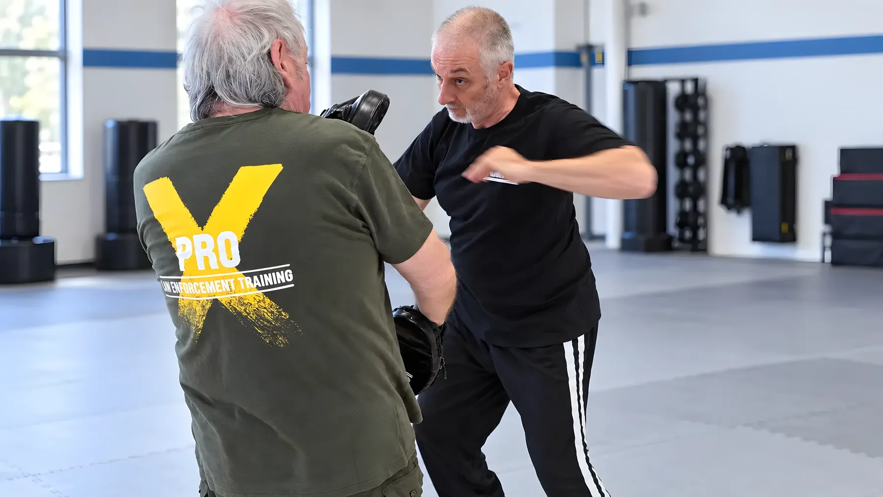 Zwei Männer bei einer Pratzenübung in der Trainingshalle