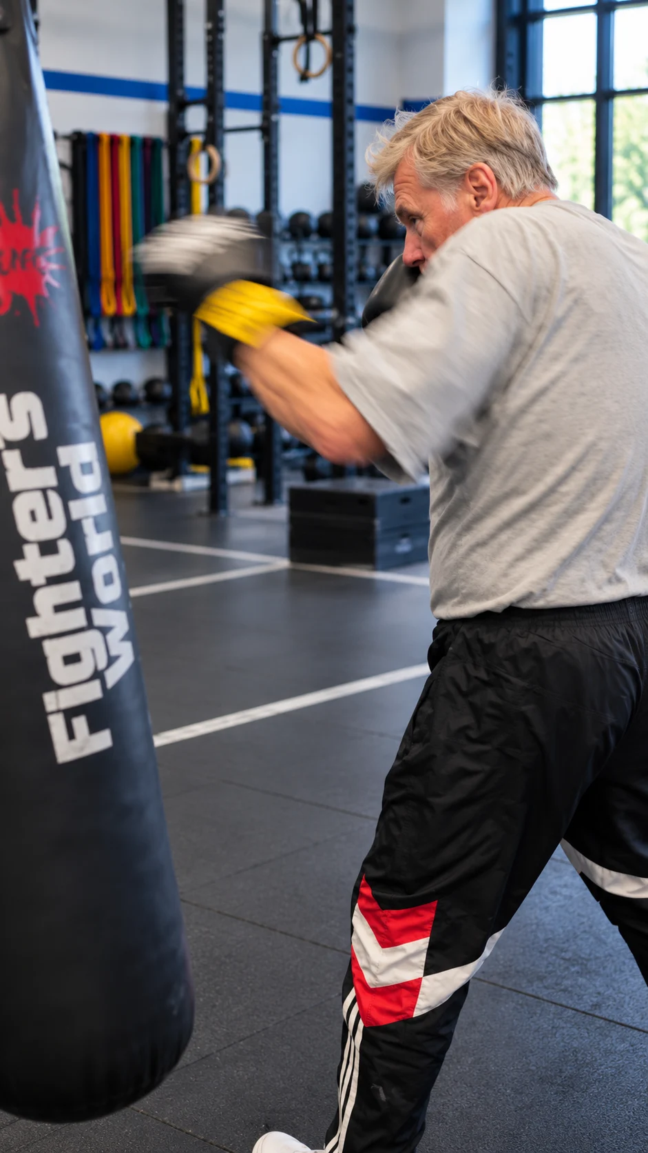 Ein älterer Mann trainiert mit Boxhandschuhen am Sandsack