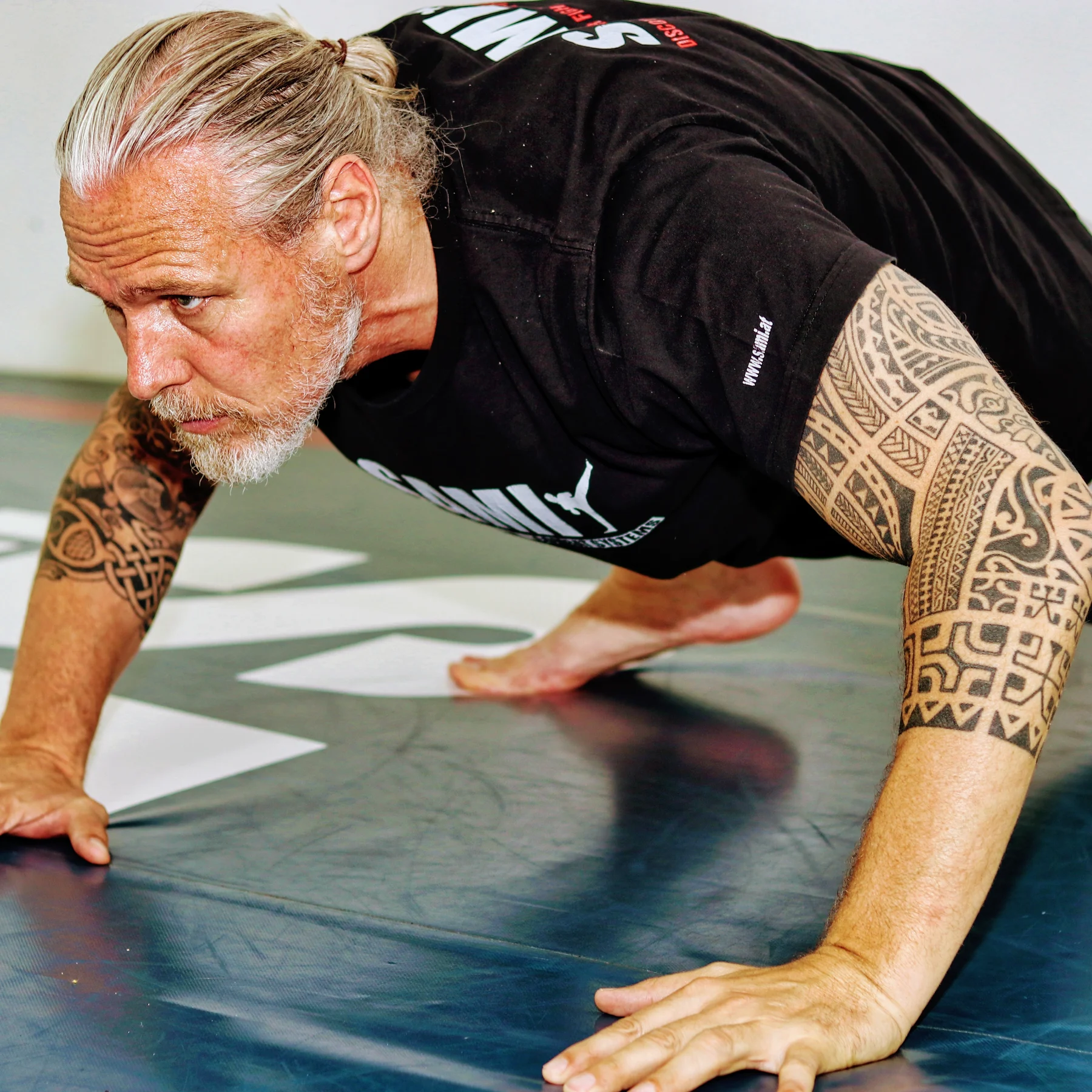 Peter Weckauf bei einer funktionellen Bodenübung auf der Trainingsmatte
