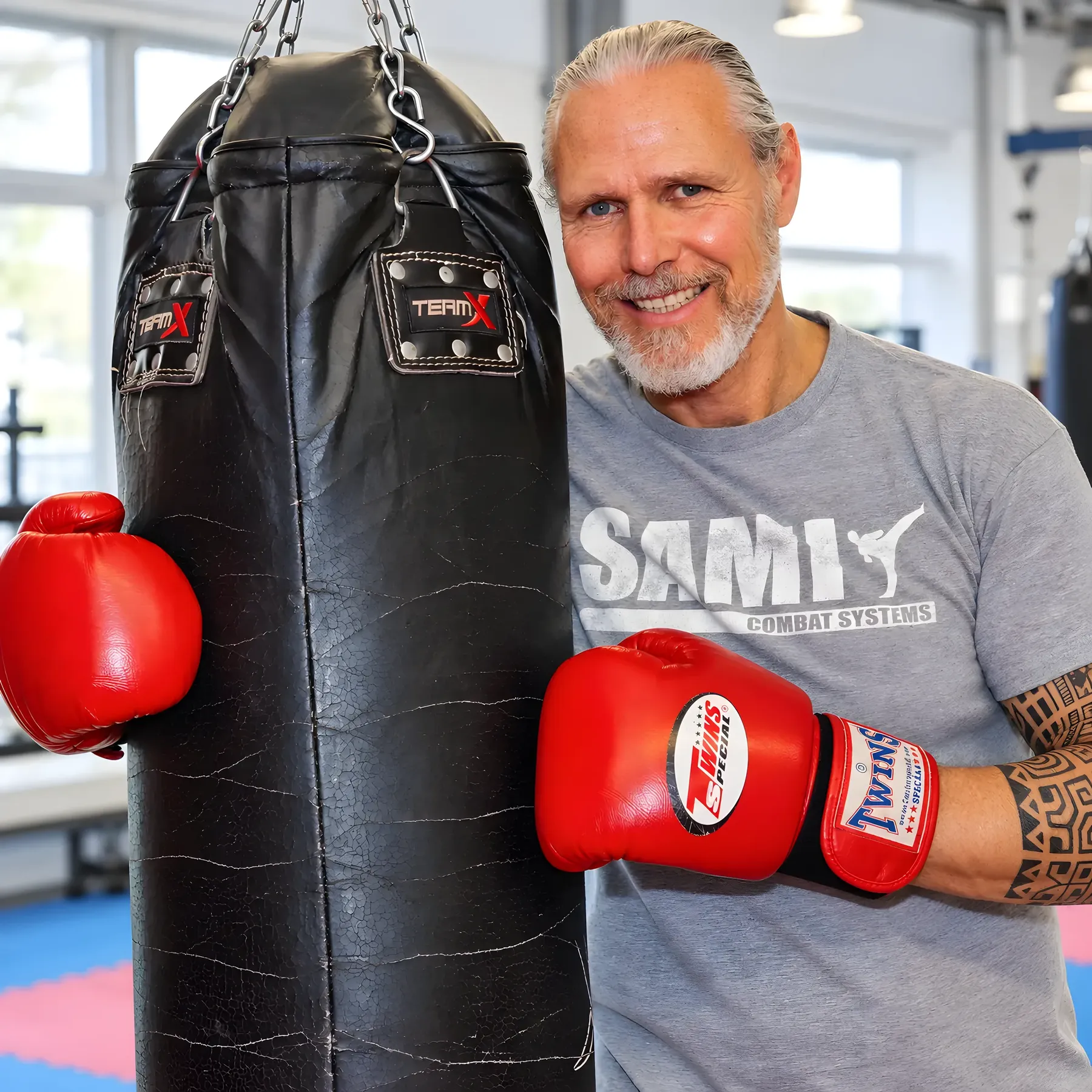 Peter Weckauf mit roten Boxhandschuhen an einem Boxsack