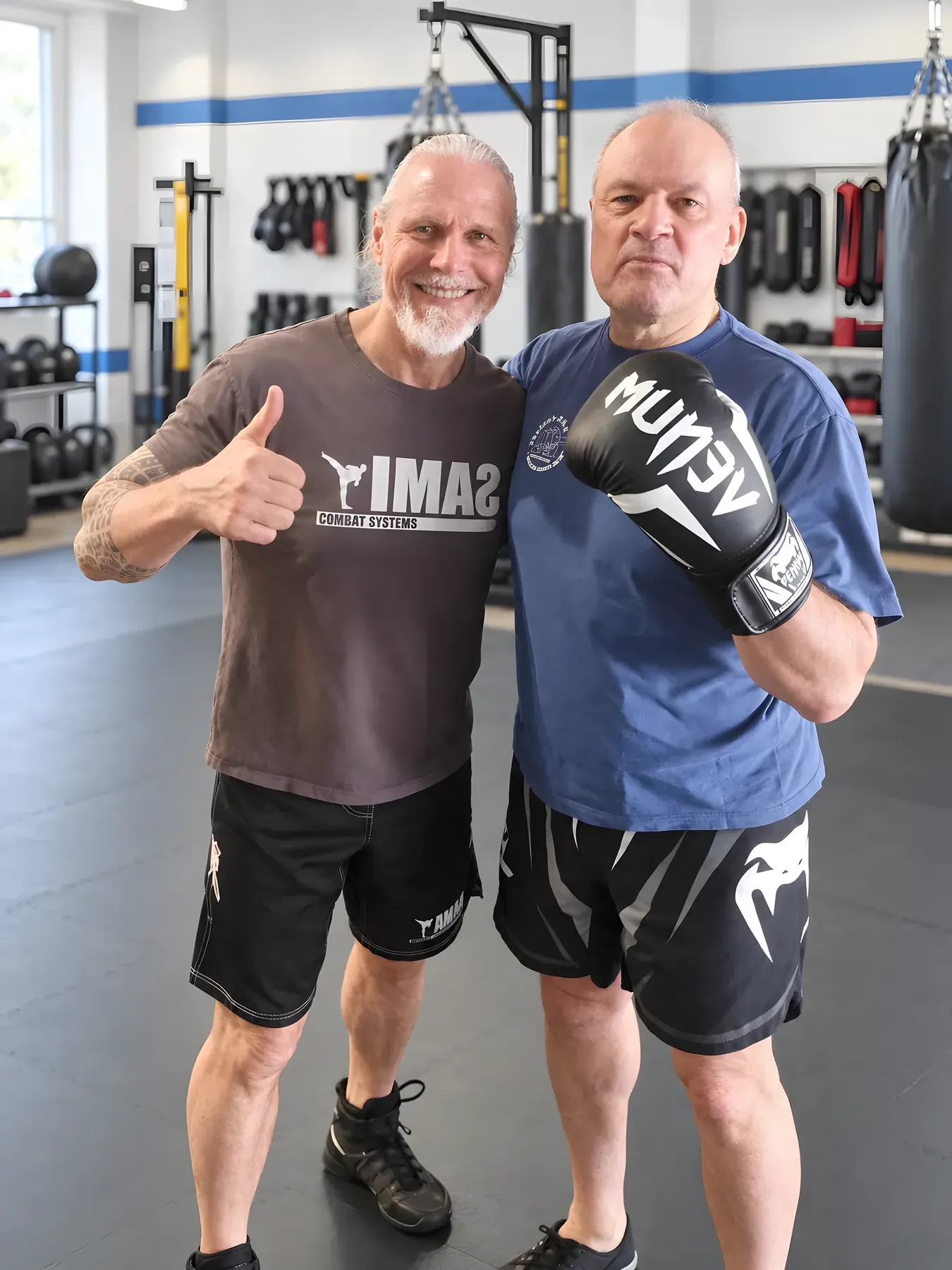 Peter Weckauf mit erhobenem Daumen neben einem Trainingspartner mit Boxhandschuhen